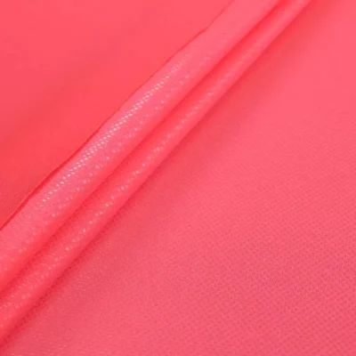 Clear dot metallic spandex in neon coral — wholesale stretch fabric