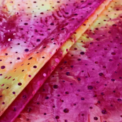Tie dye sequins stretch velvet in magenta, yellow, and orange — wholesale fabric